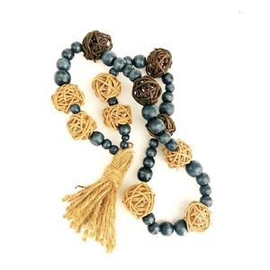 Navy blue beaded garland with neutral color wicker balls and jute tassel